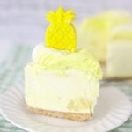 A slice of pineapple cheesecake on a white dessert plate